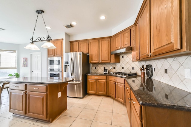 kitchen featuring stainless steel appliances, light tile patterned floors, decorative backsplash, hanging light fixtures, and a kitchen island