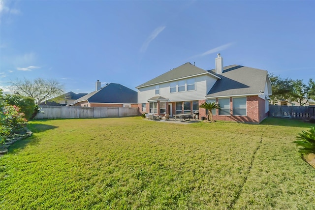 rear view of house featuring a patio and a yard