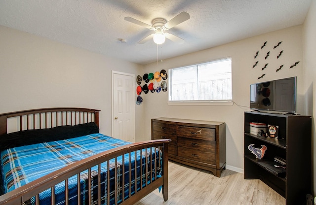 bedroom featuring a textured ceiling, ceiling fan, and light hardwood / wood-style floors