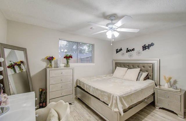 bedroom featuring a textured ceiling, ceiling fan, and light wood-type flooring