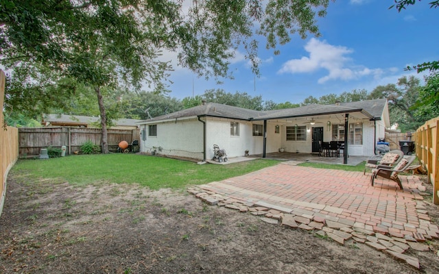 back of house featuring ceiling fan, a yard, and a patio area