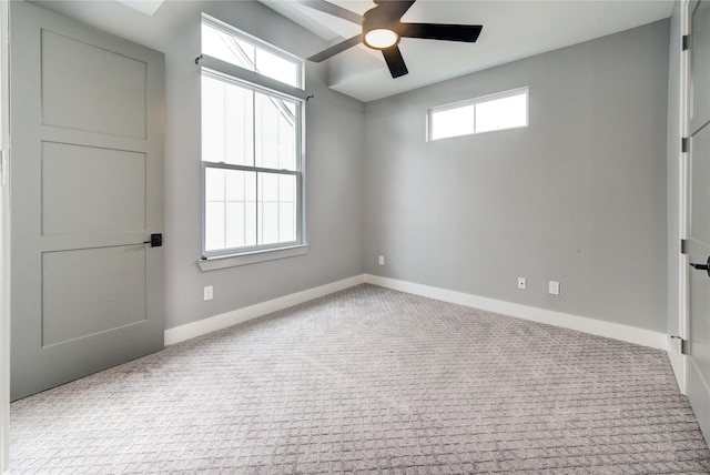 unfurnished room with ceiling fan, a wealth of natural light, and light carpet