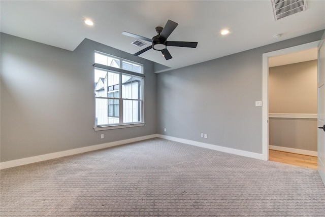 spare room featuring light colored carpet and ceiling fan