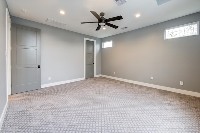 empty room featuring ceiling fan and light carpet