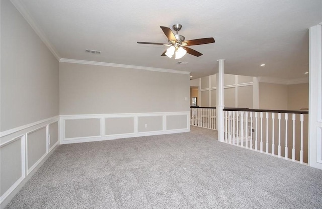 carpeted empty room with ceiling fan and crown molding