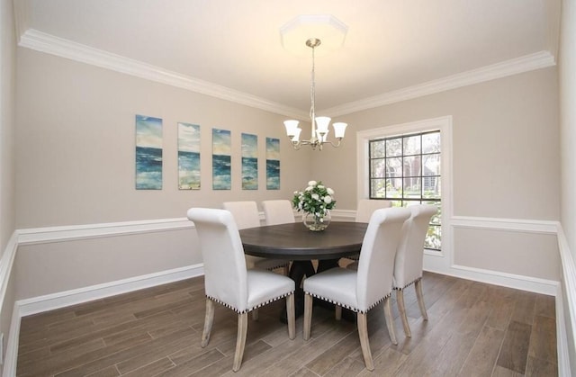 dining area with dark hardwood / wood-style flooring, ornamental molding, and a notable chandelier