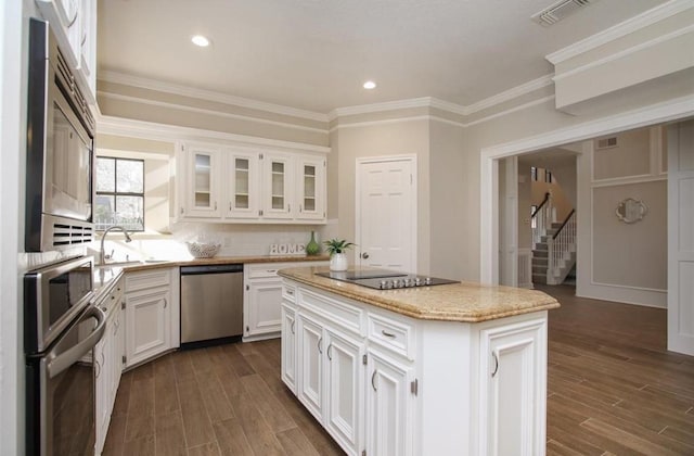 kitchen with stainless steel appliances, sink, white cabinets, dark hardwood / wood-style floors, and a kitchen island