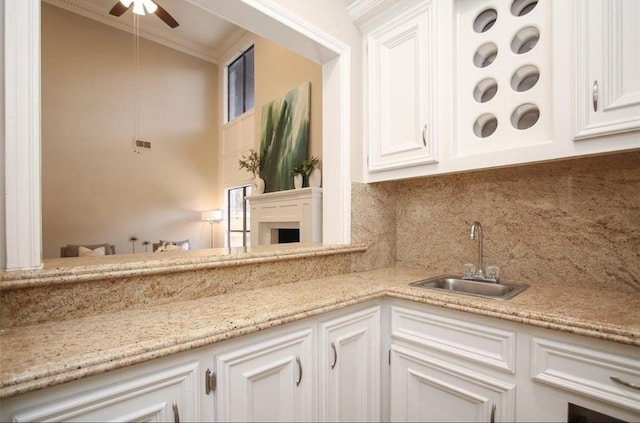 kitchen featuring sink, white cabinetry, ornamental molding, and decorative backsplash