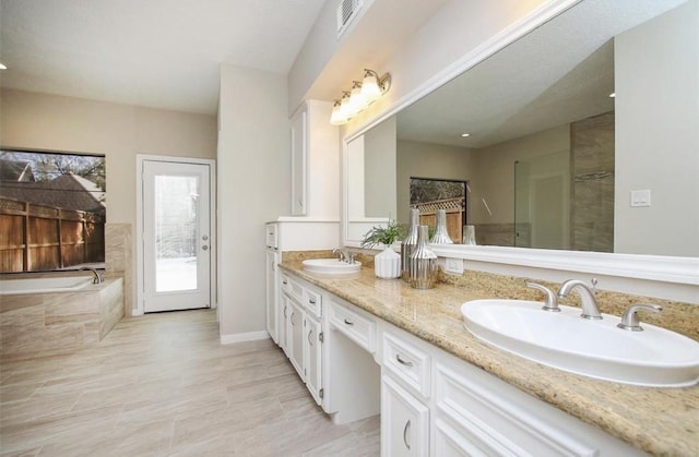 bathroom featuring vanity and a tub to relax in