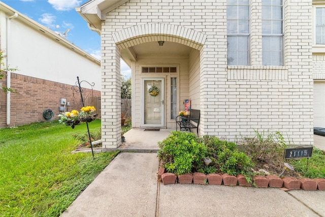 entrance to property featuring a lawn