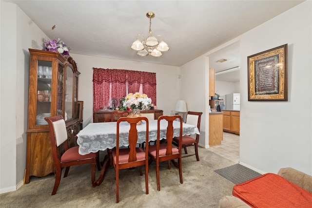 carpeted dining area featuring a notable chandelier