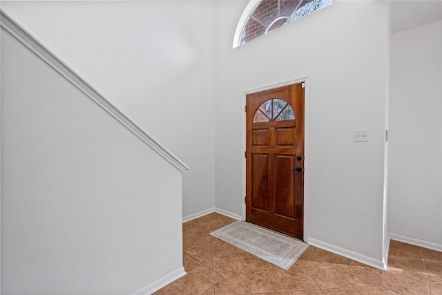 foyer featuring a towering ceiling and light tile patterned floors