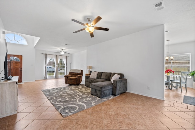 tiled living room featuring ceiling fan with notable chandelier