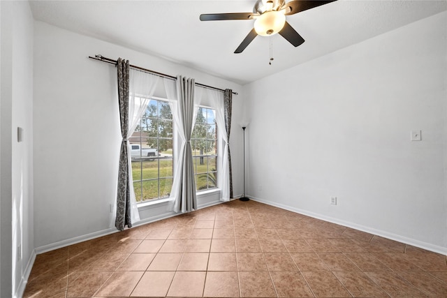 tiled empty room with ceiling fan and a wealth of natural light