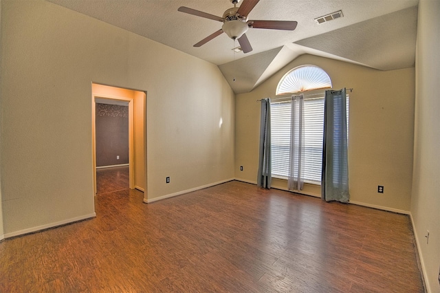 unfurnished room with ceiling fan, lofted ceiling, dark hardwood / wood-style floors, and a textured ceiling