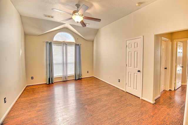 spare room with a textured ceiling, ceiling fan, vaulted ceiling, and wood-type flooring