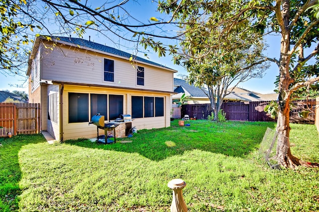 rear view of house featuring a yard