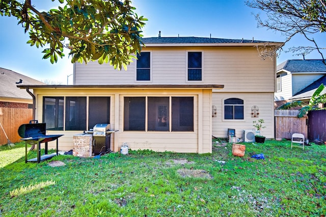 rear view of house featuring exterior kitchen, a sunroom, and a lawn