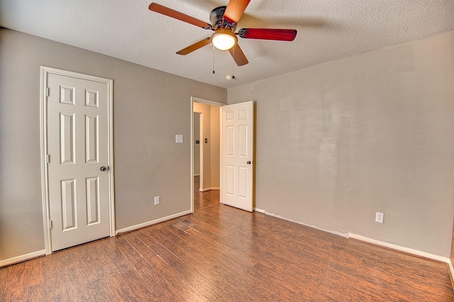 unfurnished bedroom with a textured ceiling, ceiling fan, and dark hardwood / wood-style floors