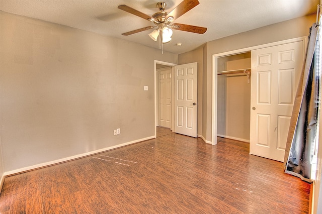 unfurnished bedroom featuring a textured ceiling, ceiling fan, a closet, and dark hardwood / wood-style floors