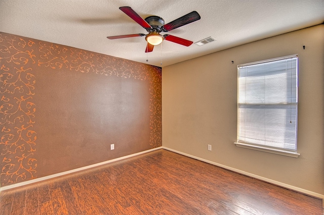 unfurnished room featuring a healthy amount of sunlight, a textured ceiling, and wood-type flooring