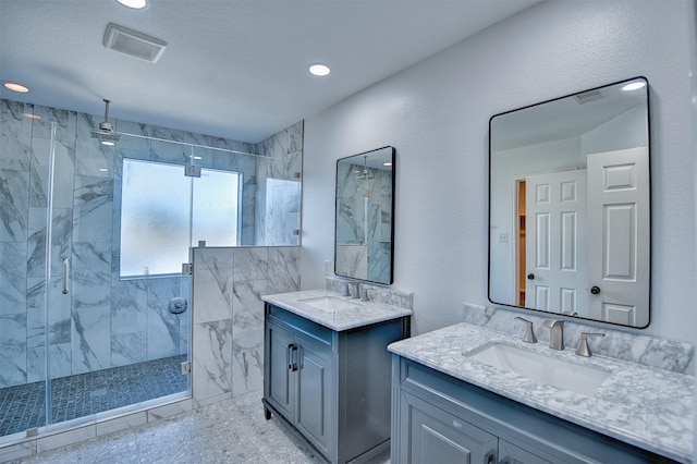 bathroom featuring a textured ceiling, an enclosed shower, and vanity