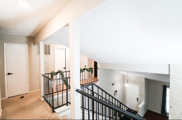 interior space featuring light carpet and vaulted ceiling