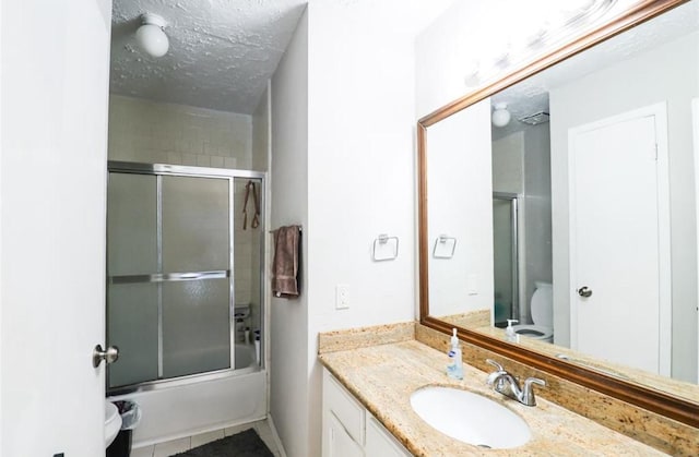 full bathroom with a textured ceiling, toilet, tile patterned floors, bath / shower combo with glass door, and vanity