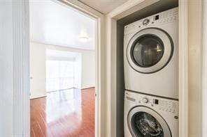 clothes washing area featuring stacked washer and clothes dryer