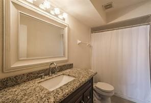 bathroom featuring vanity, toilet, and walk in shower