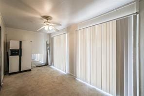 carpeted spare room featuring ceiling fan