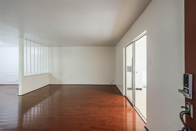 unfurnished room with dark wood-type flooring