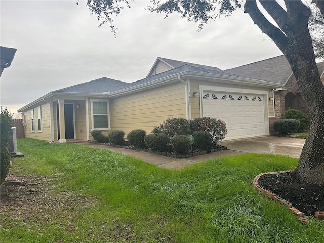 view of side of home featuring a garage and a lawn