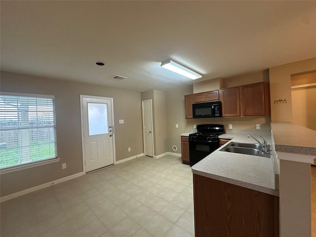 kitchen featuring kitchen peninsula, black appliances, and sink