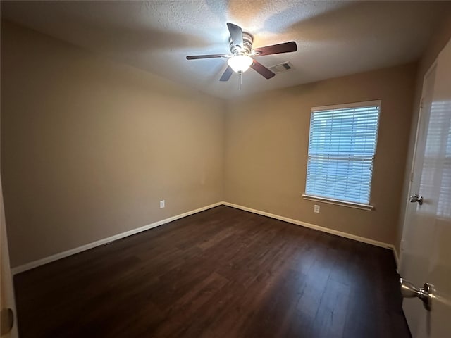 empty room featuring a textured ceiling, ceiling fan, and dark hardwood / wood-style floors