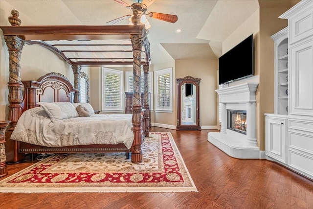 bedroom with ceiling fan, vaulted ceiling with beams, and dark wood-type flooring