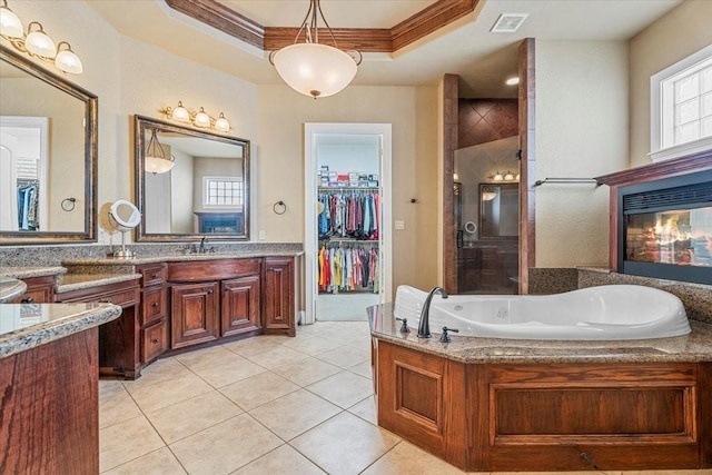 bathroom with vanity, tile patterned floors, ornamental molding, a tray ceiling, and separate shower and tub