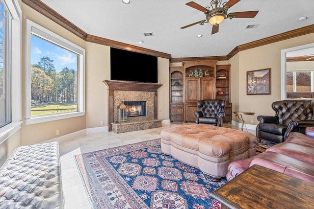 living room with a premium fireplace, ornamental molding, and ceiling fan