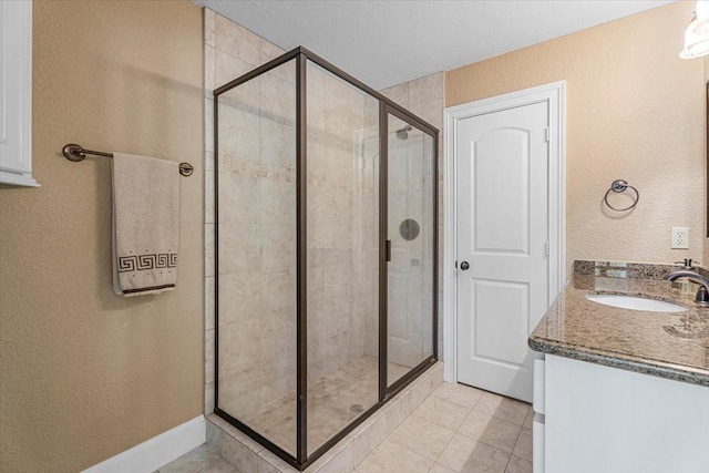 bathroom featuring tile patterned flooring, walk in shower, and vanity