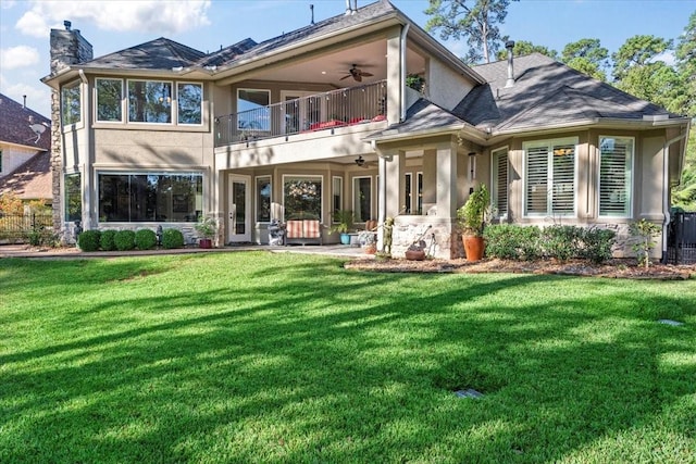 rear view of house with a lawn, a balcony, ceiling fan, and a patio