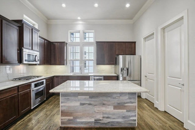 kitchen featuring a kitchen island, stainless steel appliances, and light stone counters