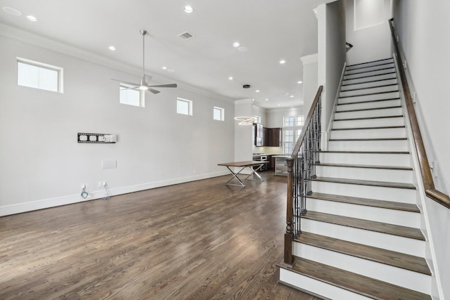 stairs featuring hardwood / wood-style flooring, ceiling fan, and crown molding