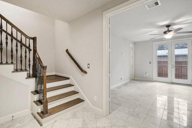 stairs with ceiling fan and french doors