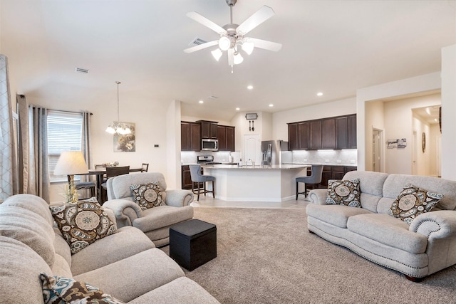 living room with ceiling fan with notable chandelier