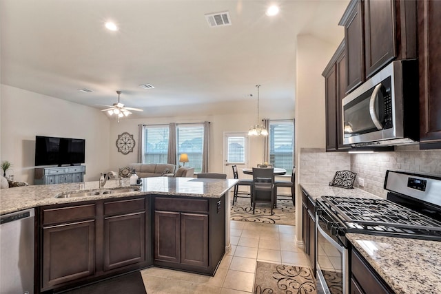 kitchen with dark brown cabinetry, sink, decorative backsplash, and appliances with stainless steel finishes