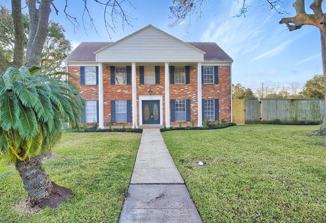 greek revival house featuring a front yard