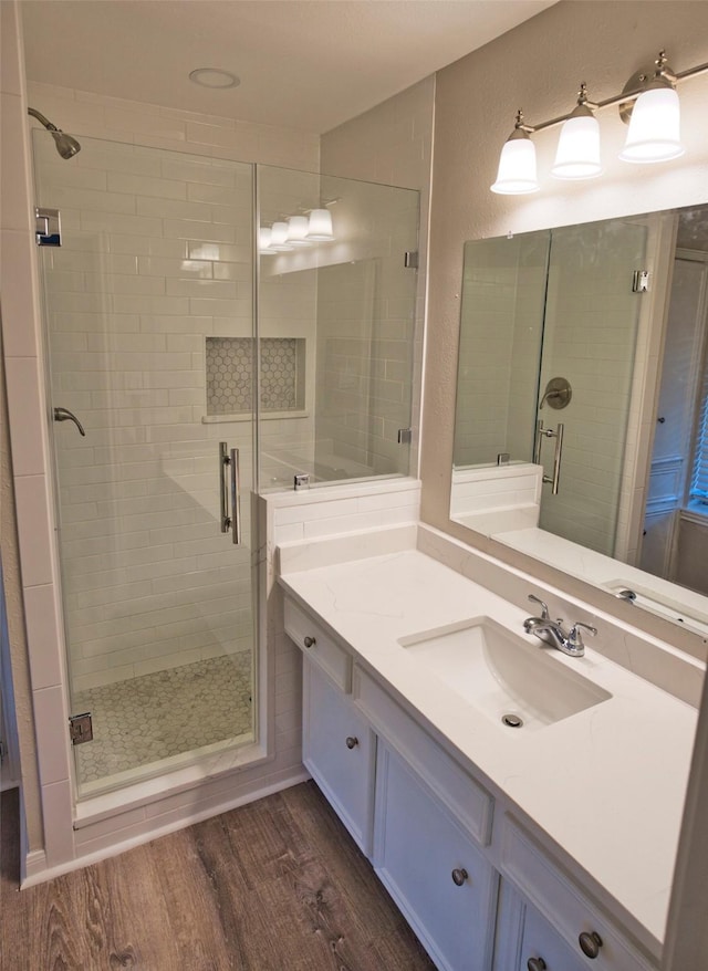 bathroom featuring a shower with shower door, vanity, and wood-type flooring