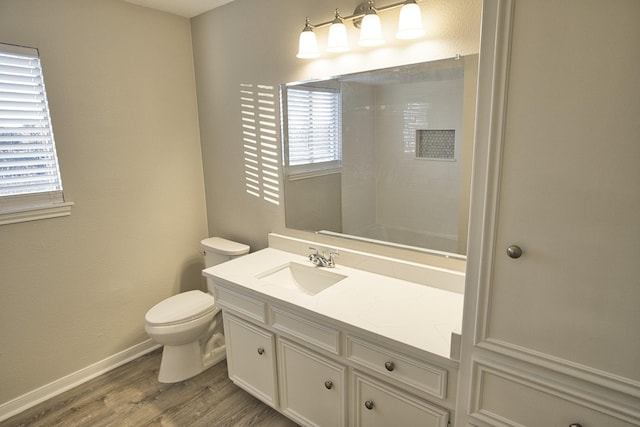 bathroom featuring toilet, a shower, wood-type flooring, and vanity