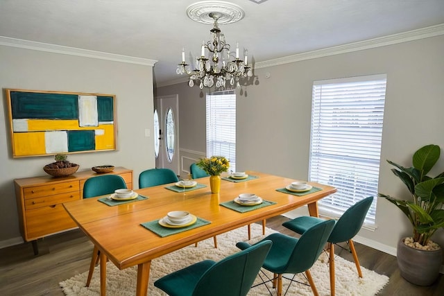 dining area with dark hardwood / wood-style flooring, ornamental molding, and a notable chandelier