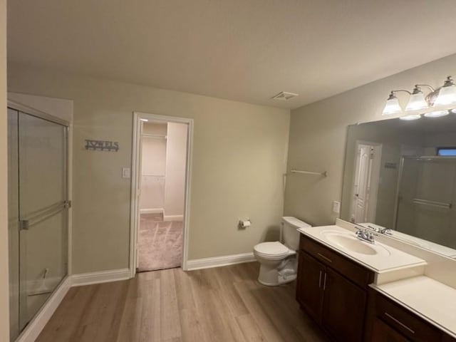 bathroom featuring toilet, a shower with door, vanity, and hardwood / wood-style floors